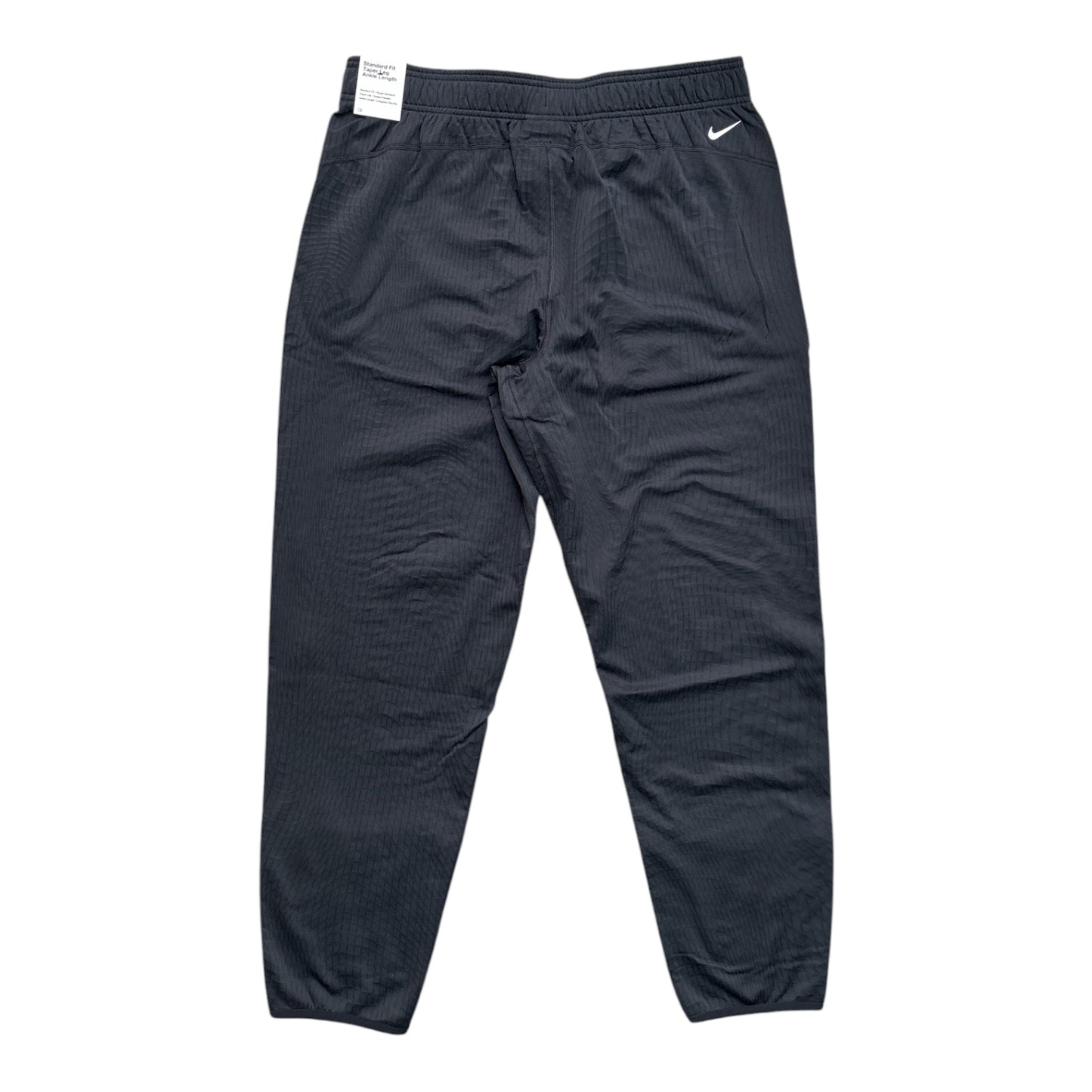 A pair of dark gray Nike athletic pants with a textured, pinstripe-like fabric pattern, featuring an elastic waistband and a small white Nike swoosh on the left hip.