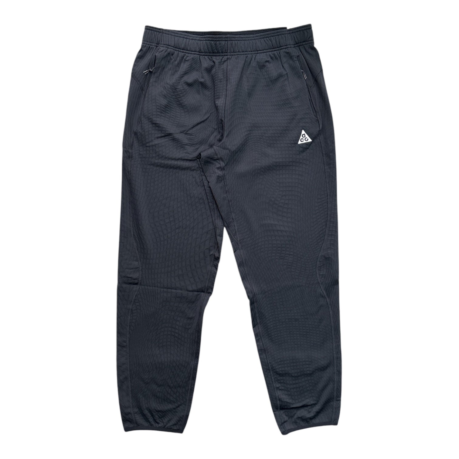 Dark gray athletic jogger pants with a textured waffle fabric, elastic waistband, side pockets, and a small white triangular logo on the left hip.