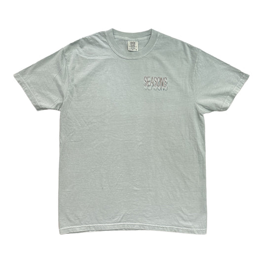 Sage colored Tee with Seasons written 3 times over the left chest.