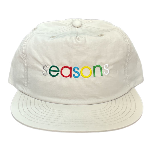 Light grey hat multi color letters saying seasons 