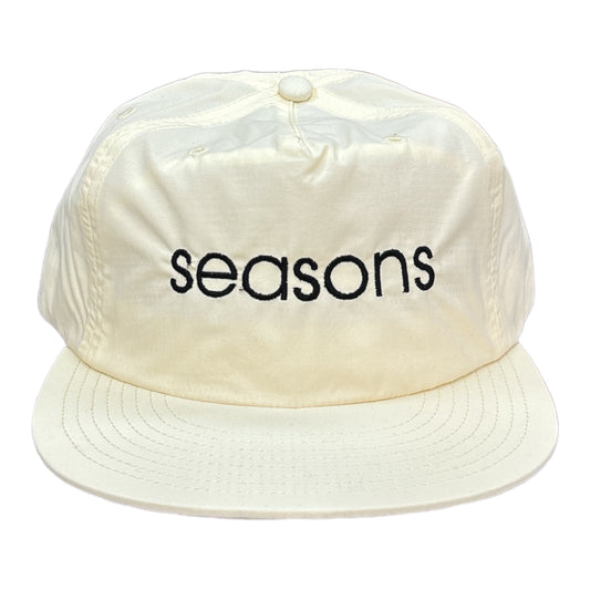 Cream colored nylon cap embroidery on front black thread spell Seasons