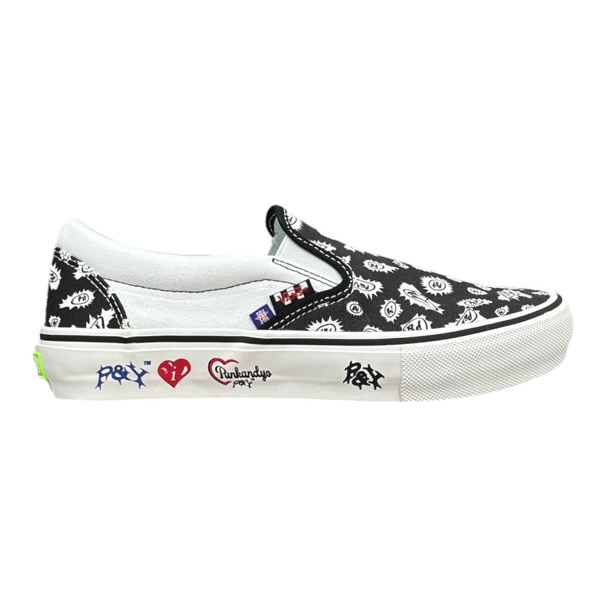 A slip-on platform sneaker featuring a black and white floral pattern on the canvas upper, a white rubber platform sole, and colorful graphic prints on the side including a red heart and blue graffiti-style text.
